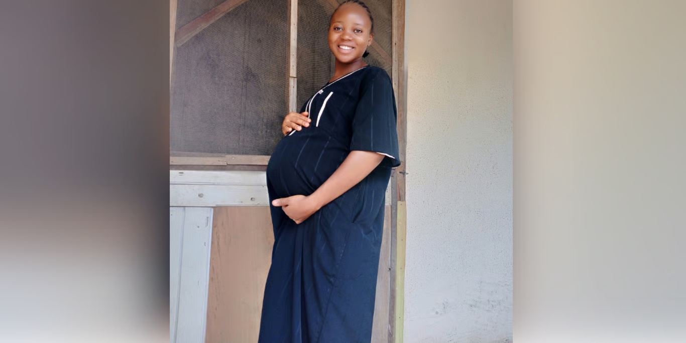Expectant mother smiling in a doorway