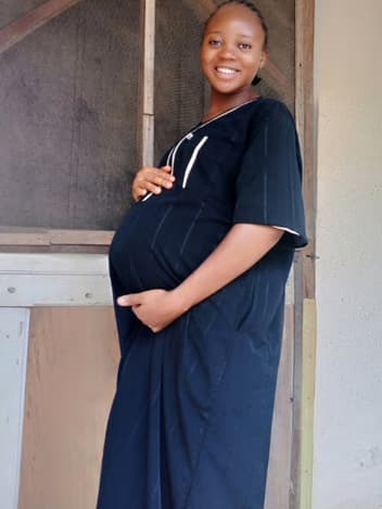 Expectant mother smiling in a doorway