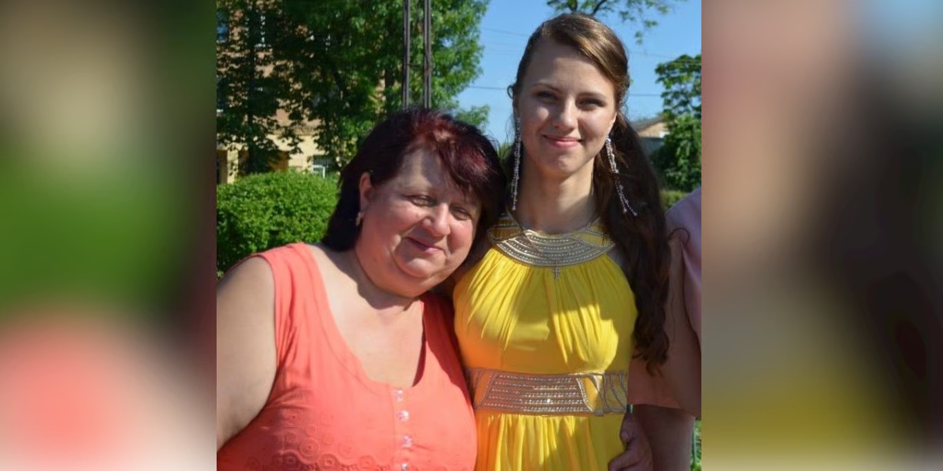 Mother and daughter smiling outdoors