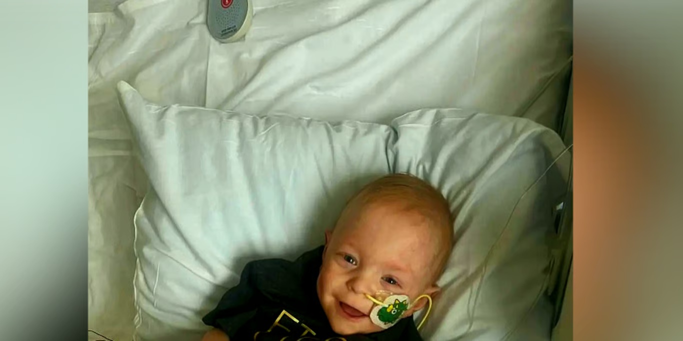 Smiling baby resting in a hospital bed