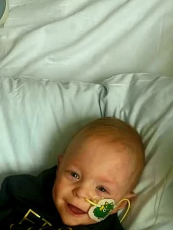 Smiling baby resting in a hospital bed