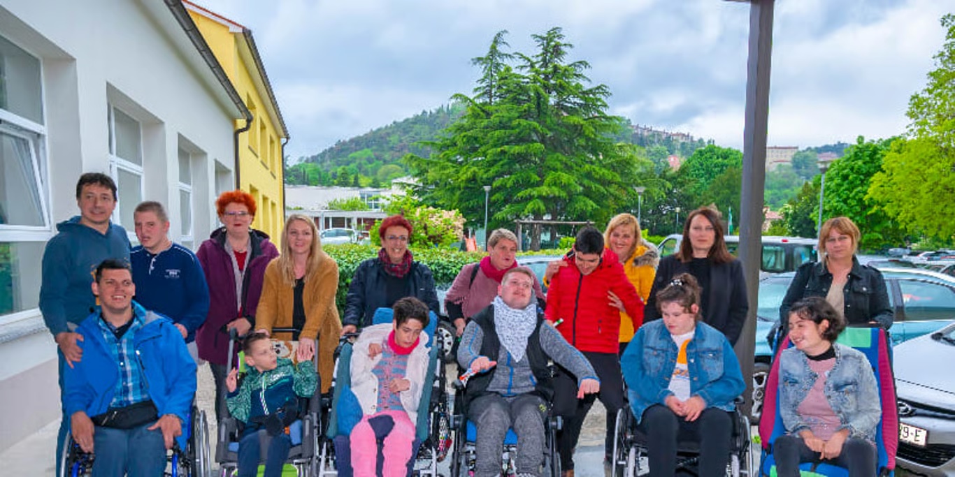 Group of wheelchair users and carers outdoors