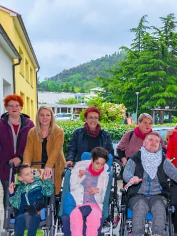 Group of wheelchair users and carers outdoors