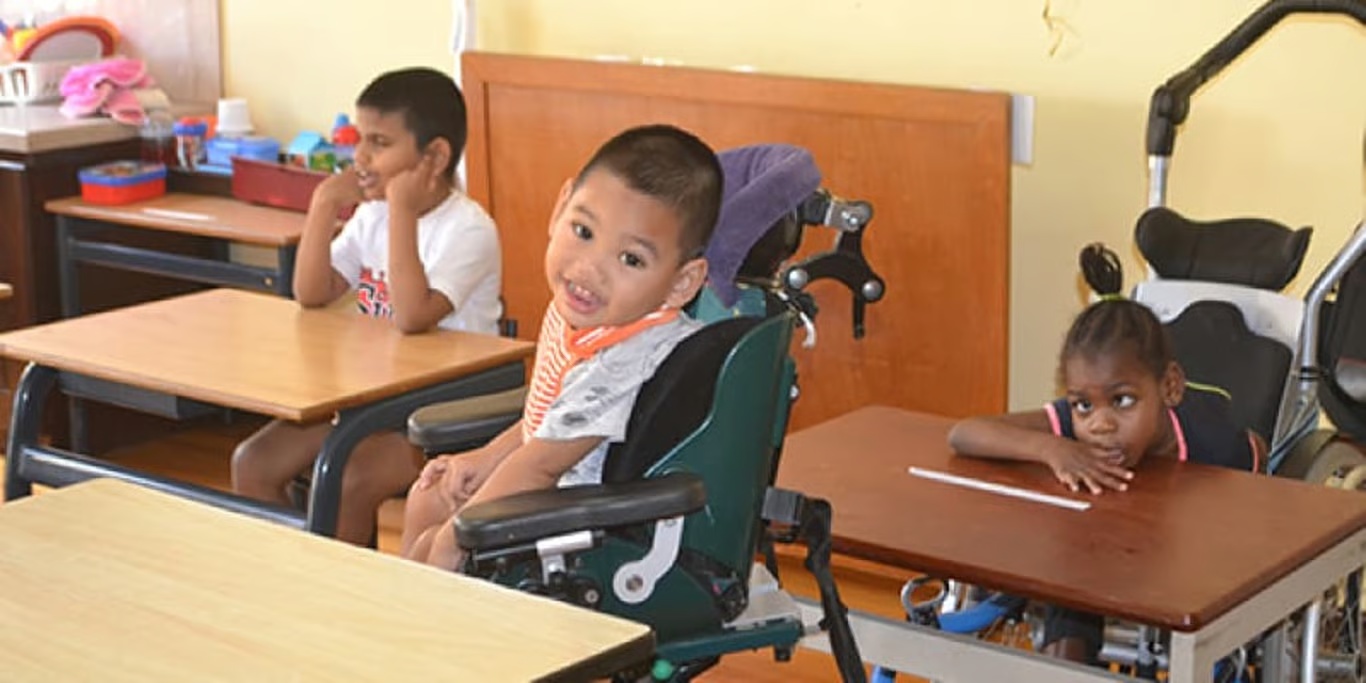 Smiling boy in his wheelchair at school