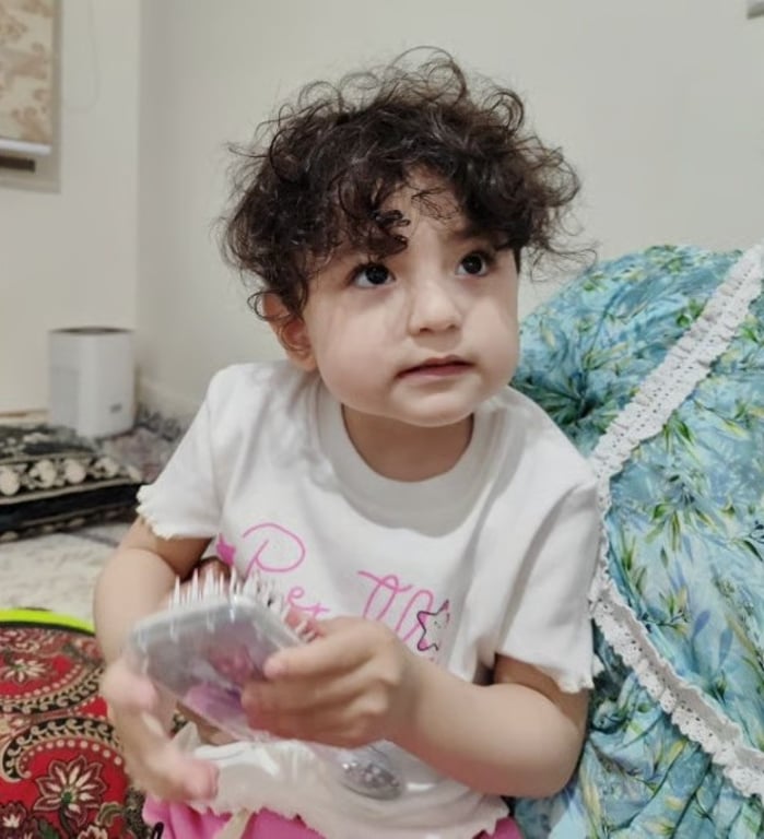 Toddler with curly hair at home