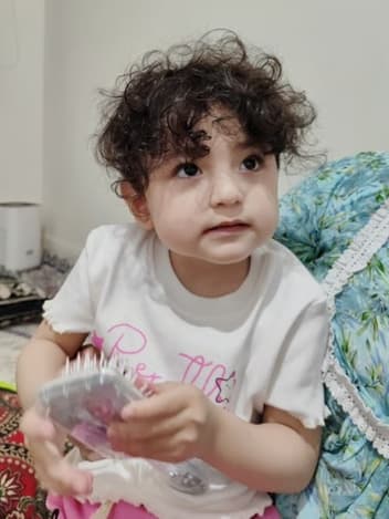 Toddler with curly hair at home