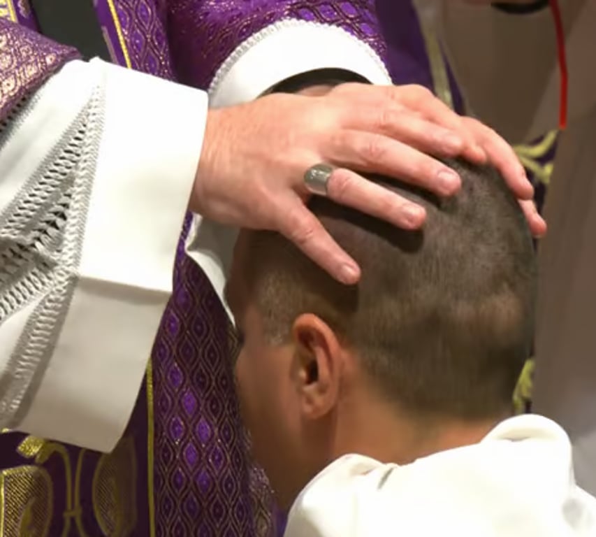 Priester legt handen op tijdens een zegening