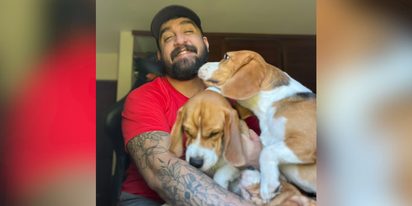 Man hugging his two rescued beagles