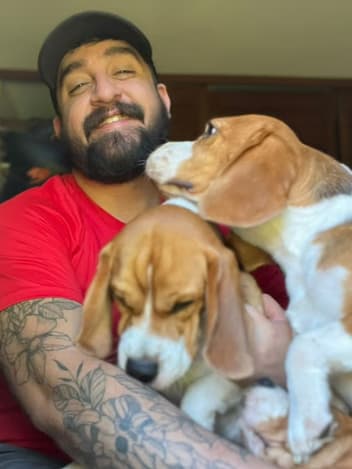 Man hugging his two rescued beagles
