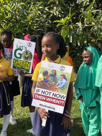 Schoolchildren holding Go Green signs