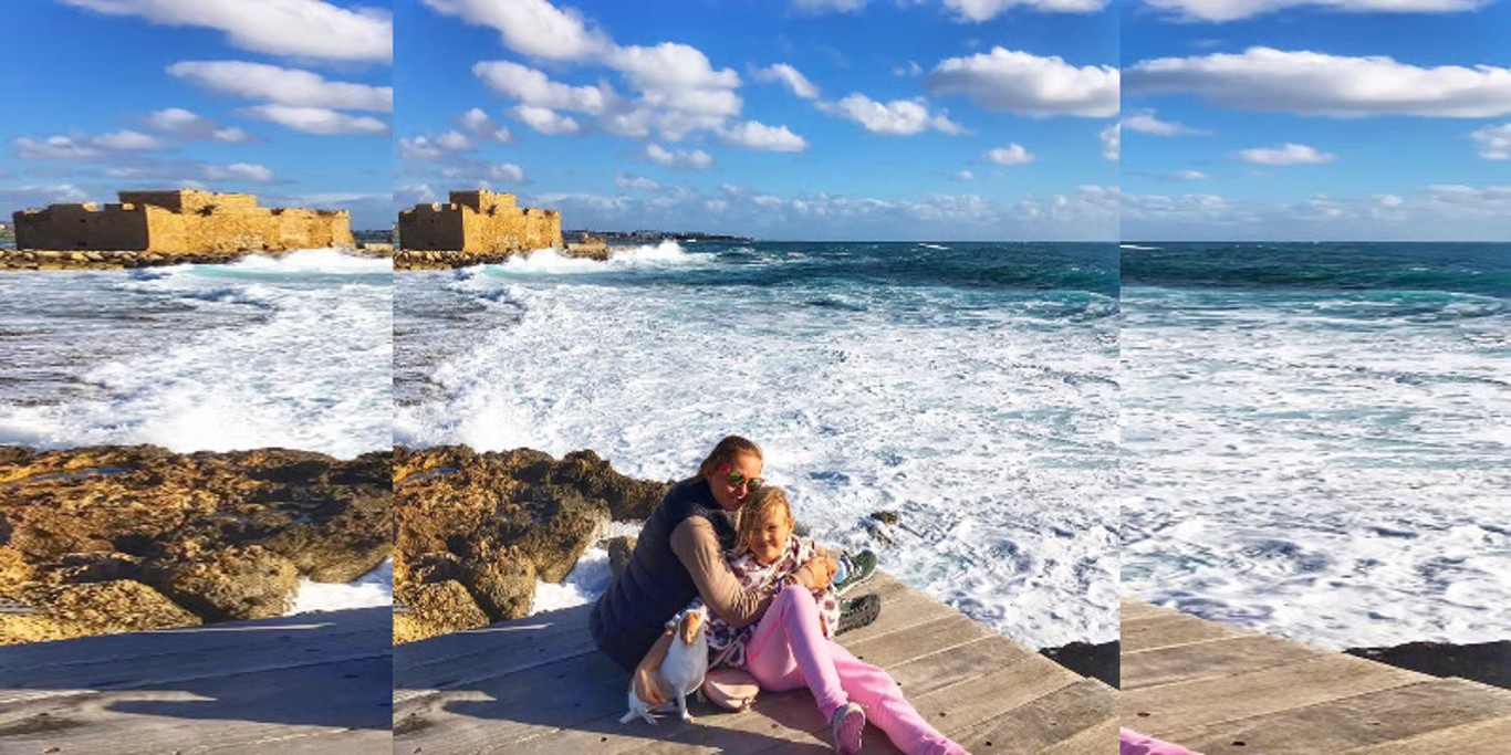 Mother hugging her daughter by the sea
