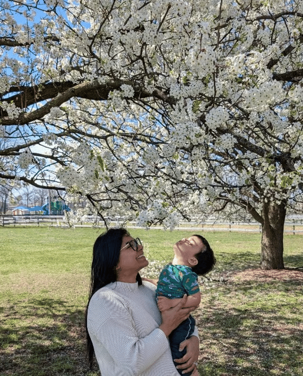 Mother holding her son under a blossoming tree