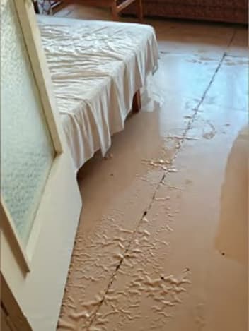 Mud-covered bedroom floor after a flood