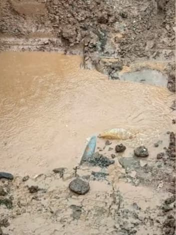 Muddy floodwater pooling over debris