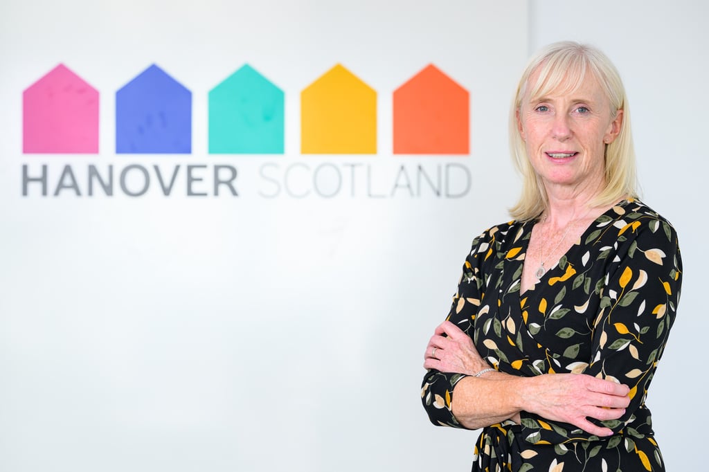 Scottish PR Photography, Angela Currie, Chief Executive of Hanover Scotland standing in front of logo