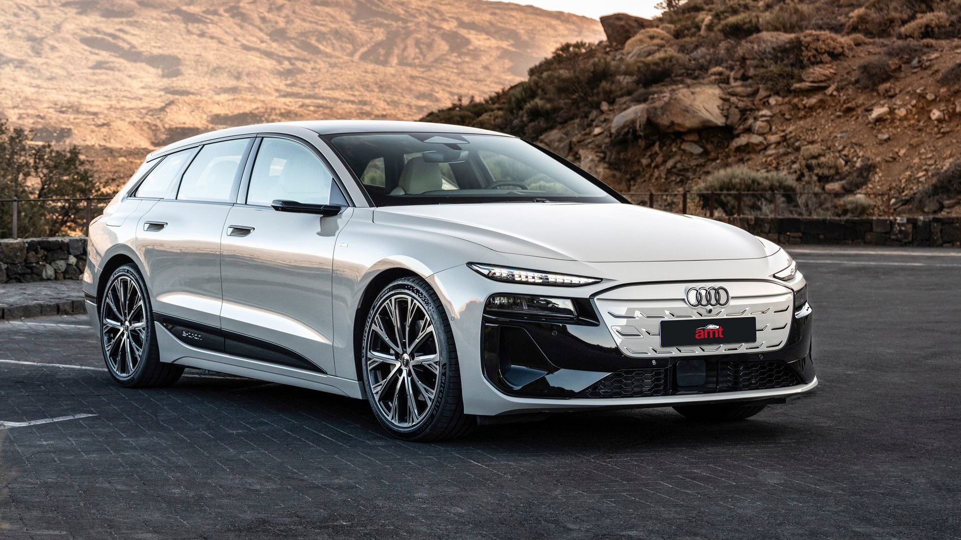 The futuristic Audi A6 Avant e-tron in a stunning silver finish, set against a rugged mountainous terrain for the 2025 model year.