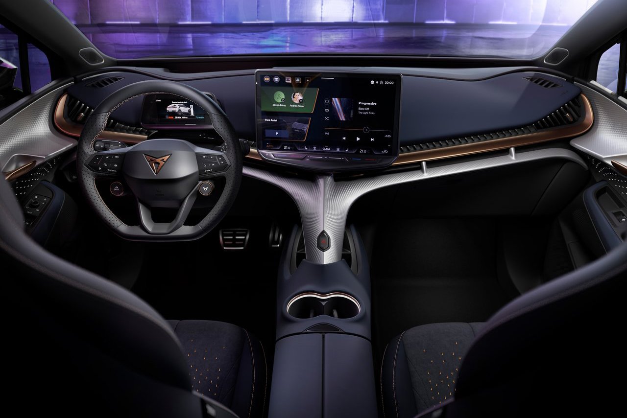 The interior of the Cupra Tavascan, displaying a futuristic dashboard with a large central screen, premium materials, and a stylish, ergonomic steering wheel.