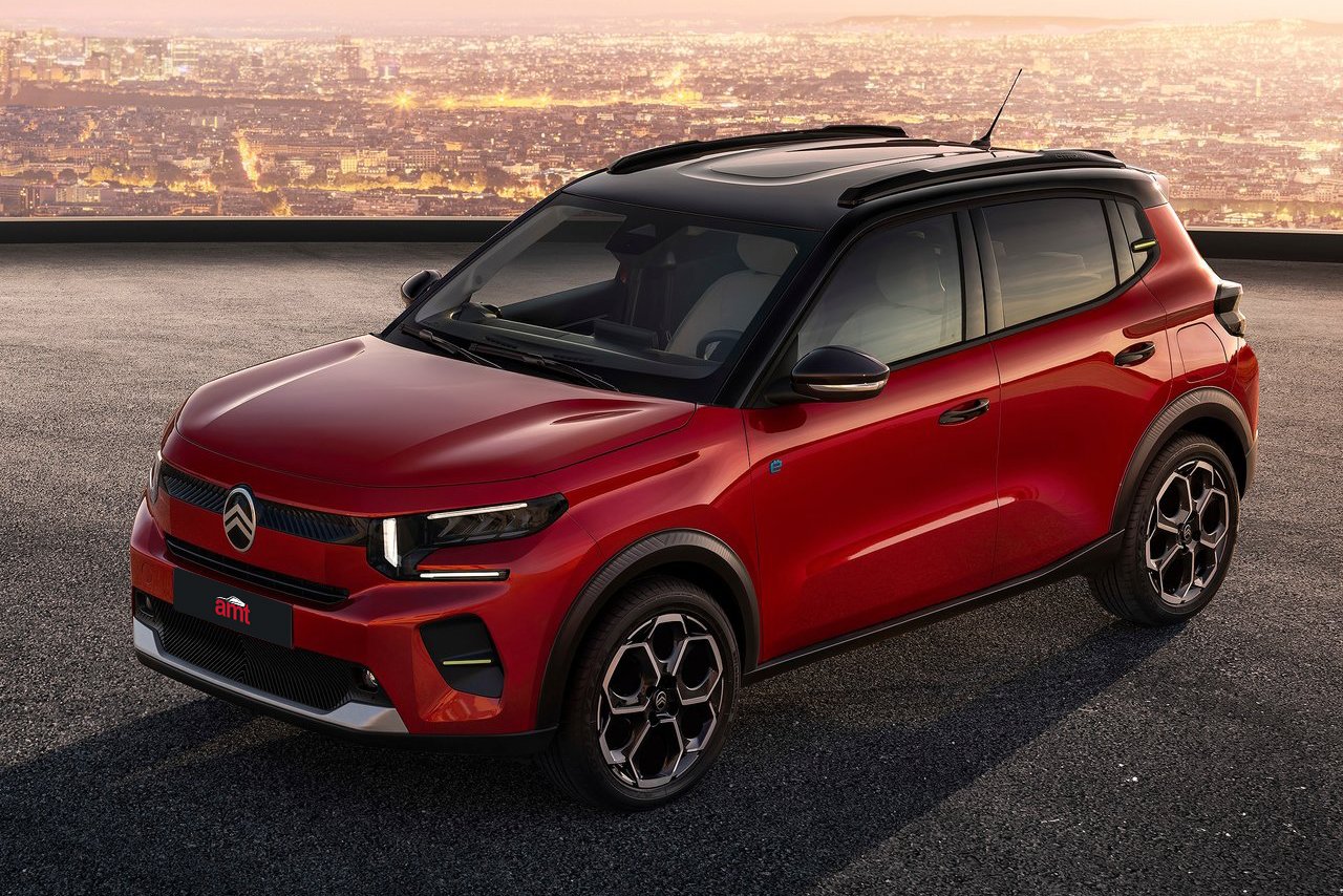 The 2025 Citroën e-C3 in red with futuristic accents, positioned on an urban rooftop against a glowing cityscape.