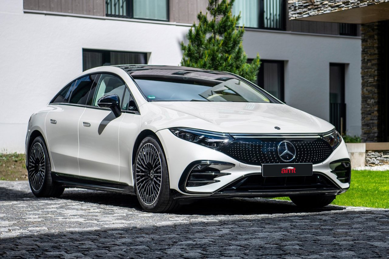 A white Mercedes-Benz EQS parked on a cobblestone driveway, representing the pinnacle of electric luxury in 2025.