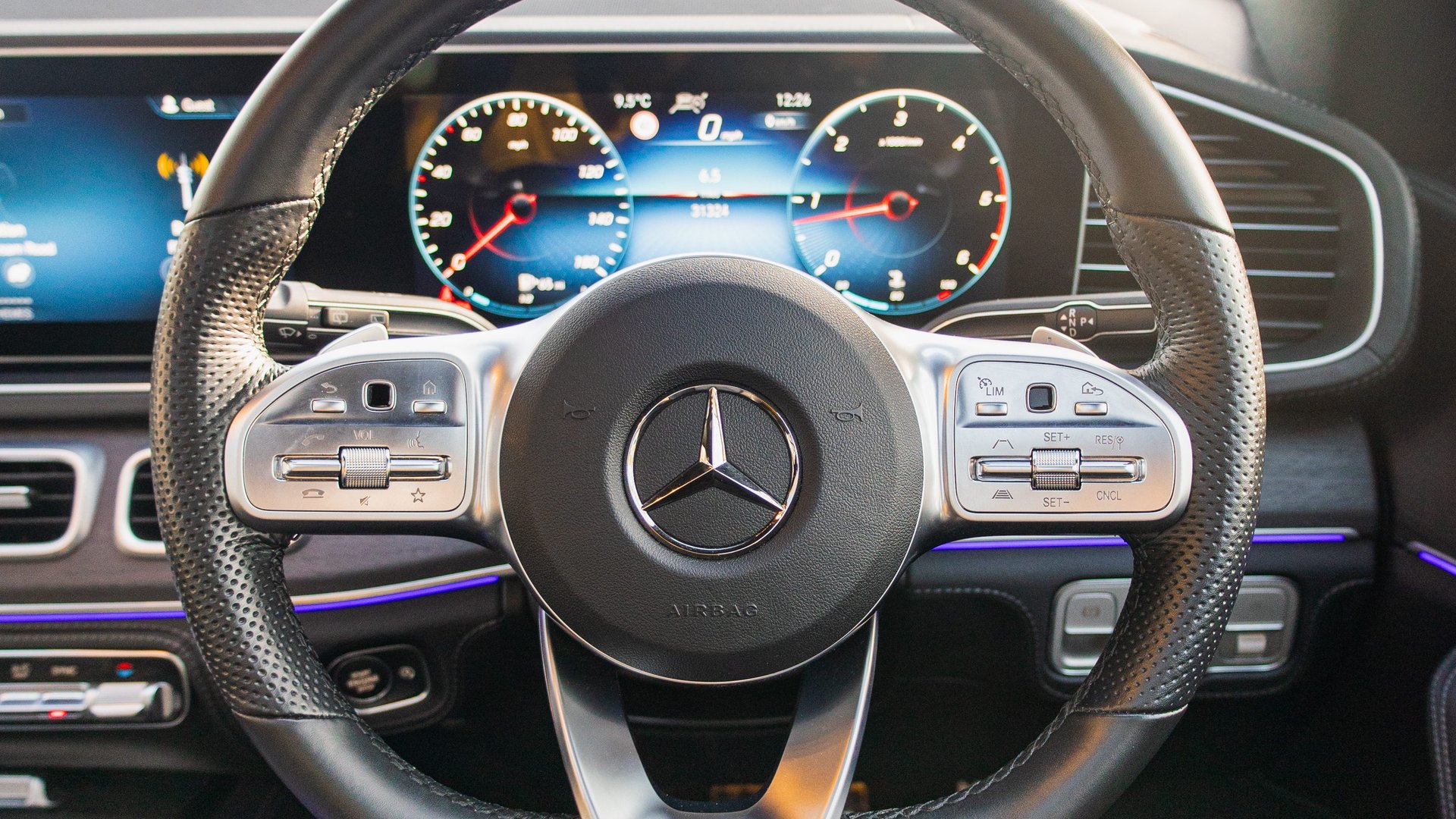 Close-up of the Mercedes-Benz GLE steering wheel with digital dashboard, showcasing the modern technology and performance-oriented design elements in the Mercedes-Benz GLE review.