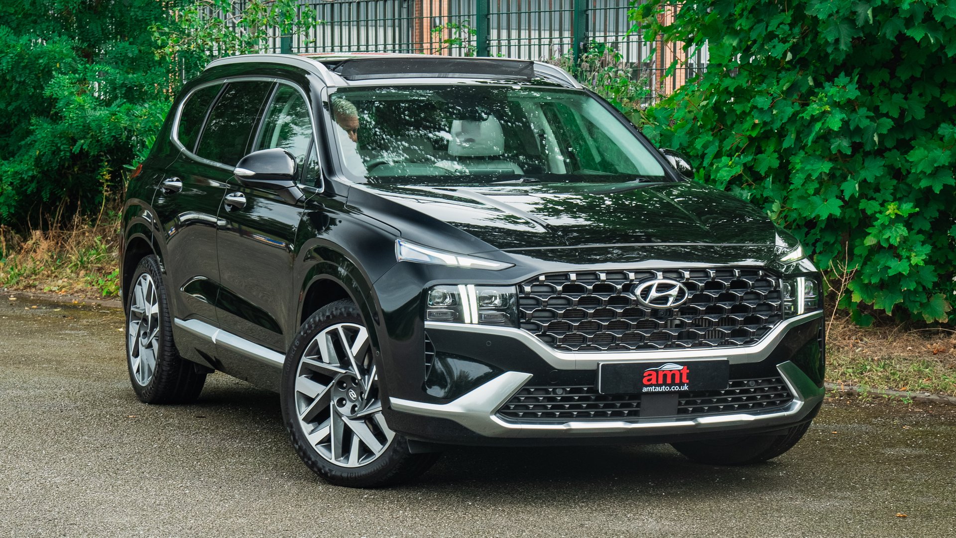The sophisticated Hyundai Santa Fe in black, photographed outside a vibrant setting, offering versatility for 2025.