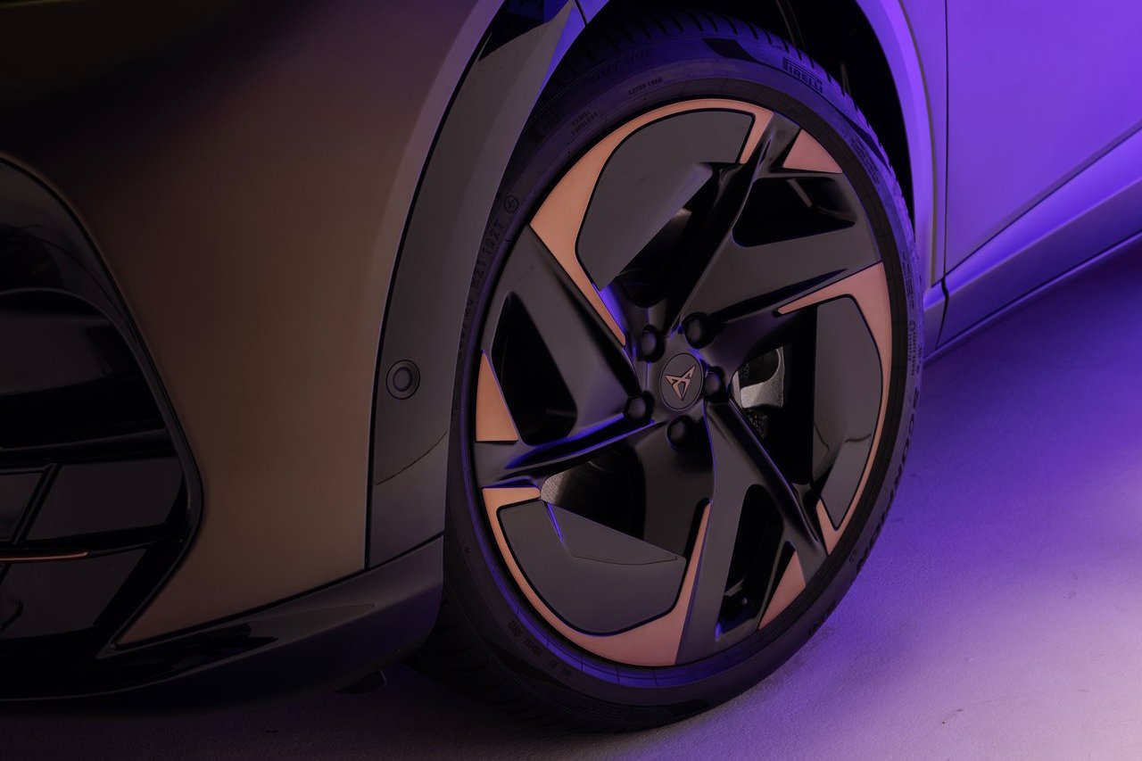 A close-up of the Cupra Tavascan's alloy wheel, featuring an intricate and futuristic design with bronze and black accents.