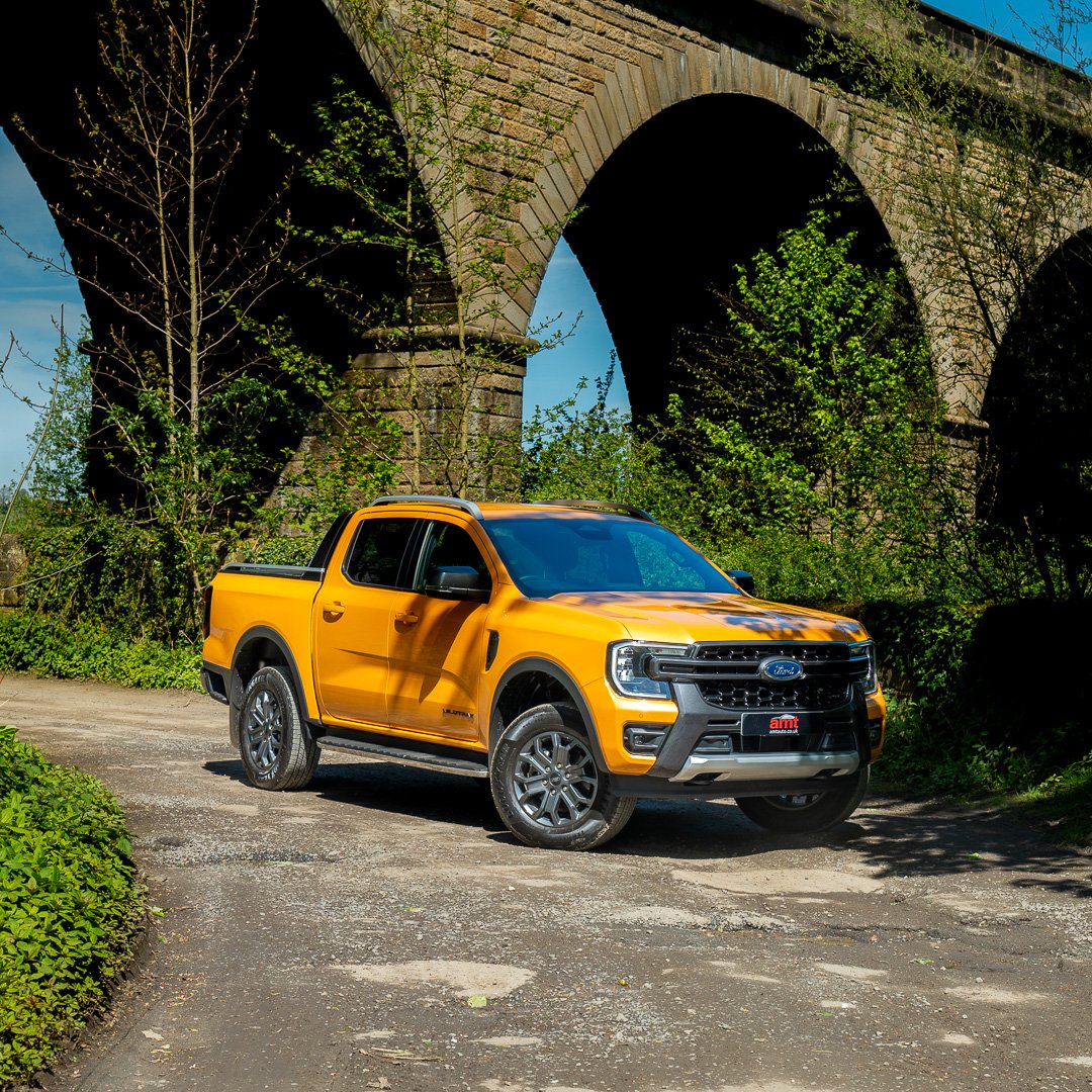 Ford Ranger parked outdoors with a bridge in the background, highlighting its rugged off-road capability and stylish design, available for ford ranger lease through AMT Auto
