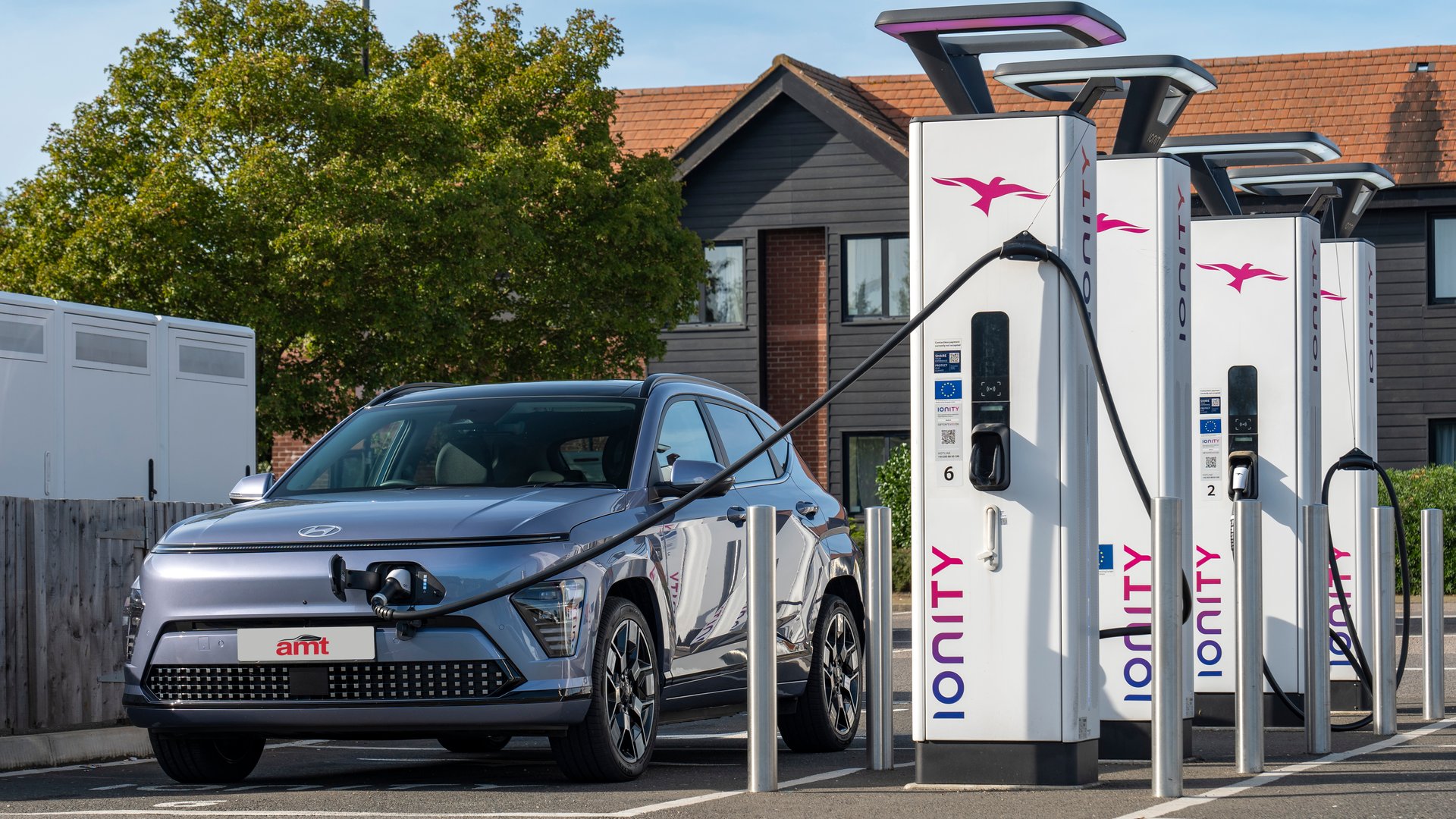Hyundai Kona Electric charging at a public charging station, showcasing its convenience and suitability for eco-friendly travel.