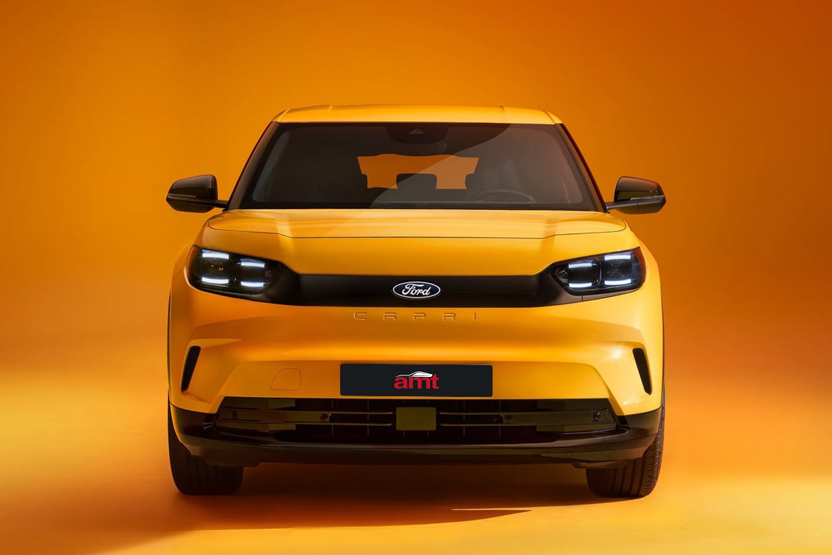 Detailed view of a yellow Ford Capri's front, showcasing its clean grille design, illuminated headlights, and aerodynamic accents.