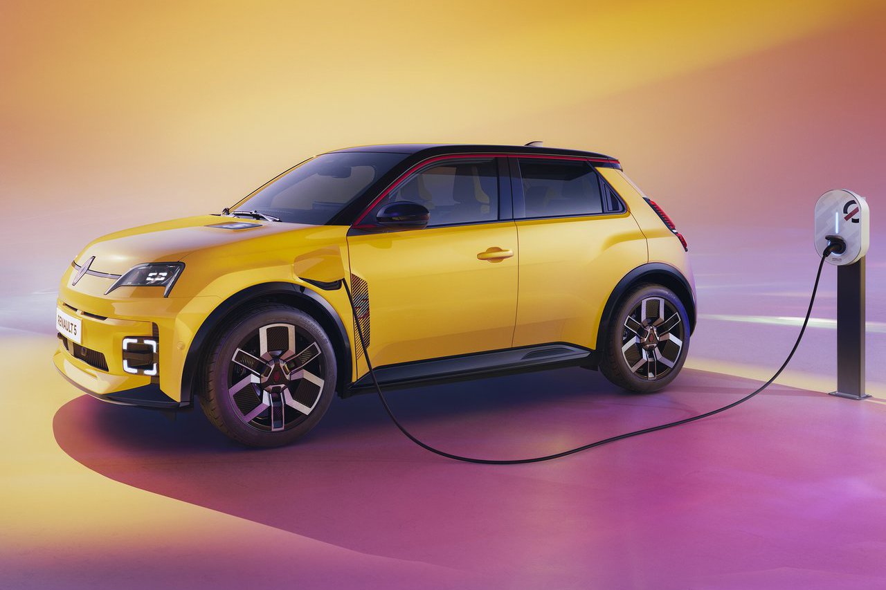 The Renault 5 in yellow connected to an electric charging station, symbolising its eco-friendly electric powertrain.