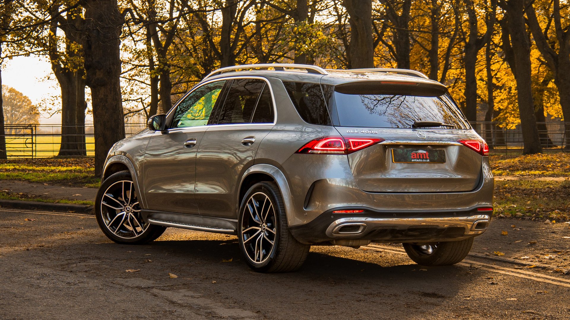 Rear three-quarter view of the Mercedes-Benz GLE parked in a leafy park, illustrating the SUV's elegant rear design and spacious build for the Mercedes-Benz GLE review.