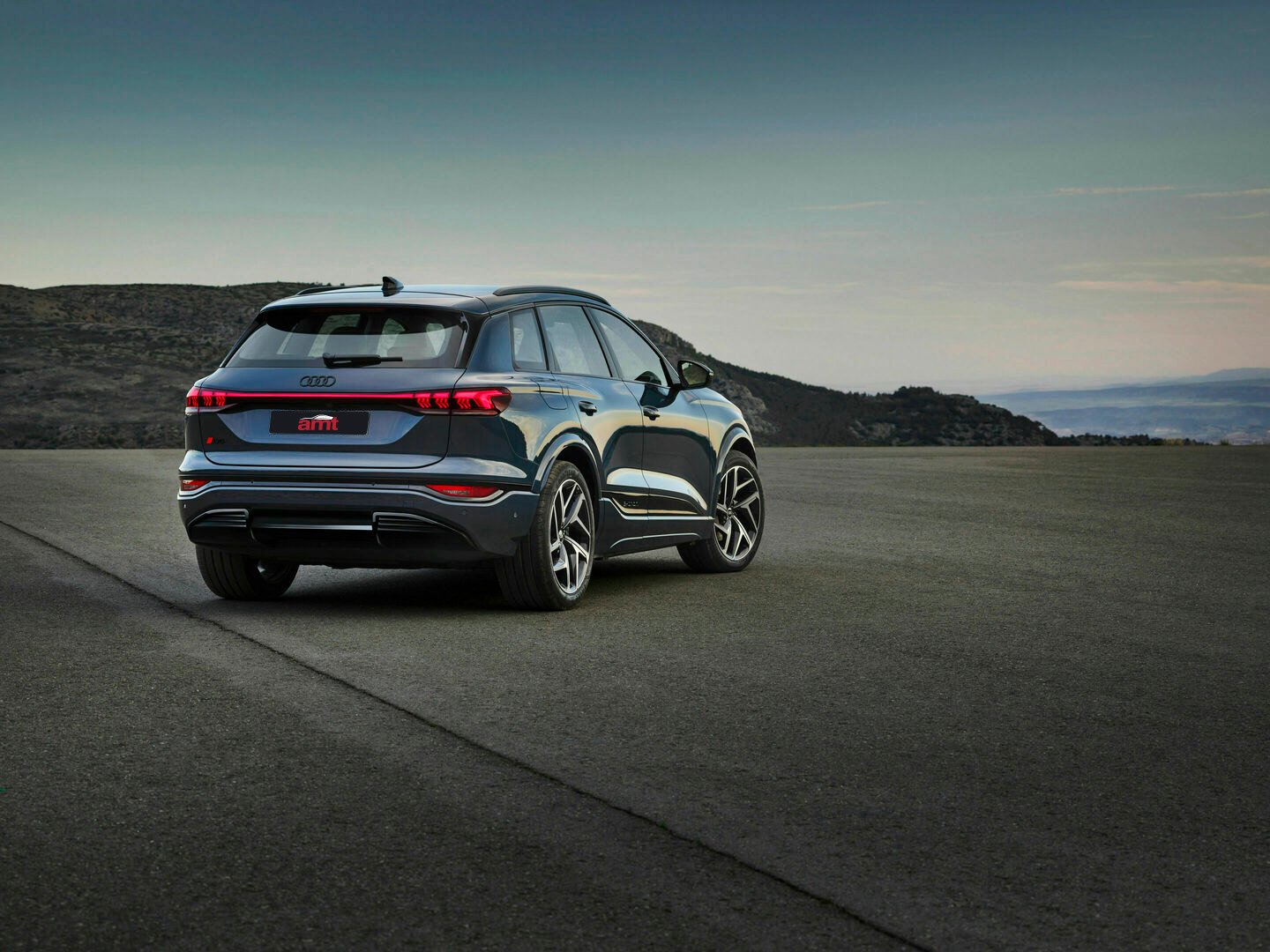 Audi Q6 e-tron rear view, displaying sleek design and Quattro all-wheel drive features, available for leasing at AMT Auto.