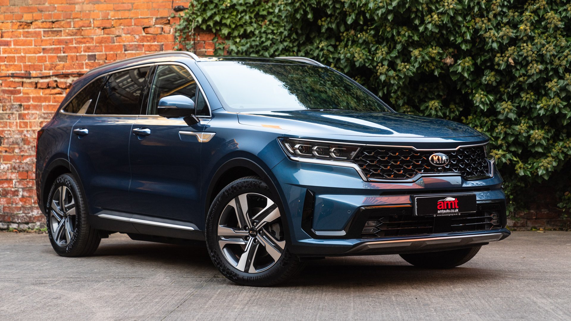 The premium Kia Sorento in deep blue, positioned in an urban courtyard to highlight its practicality and style for 2025.