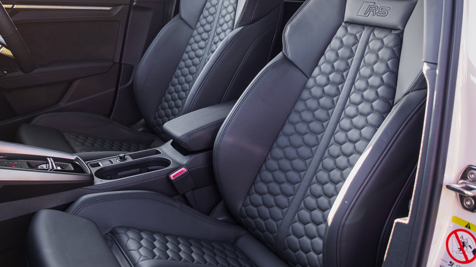 The luxurious front seats of the Audi RS3, upholstered in black leather with quilted stitching and RS branding for a premium finish.