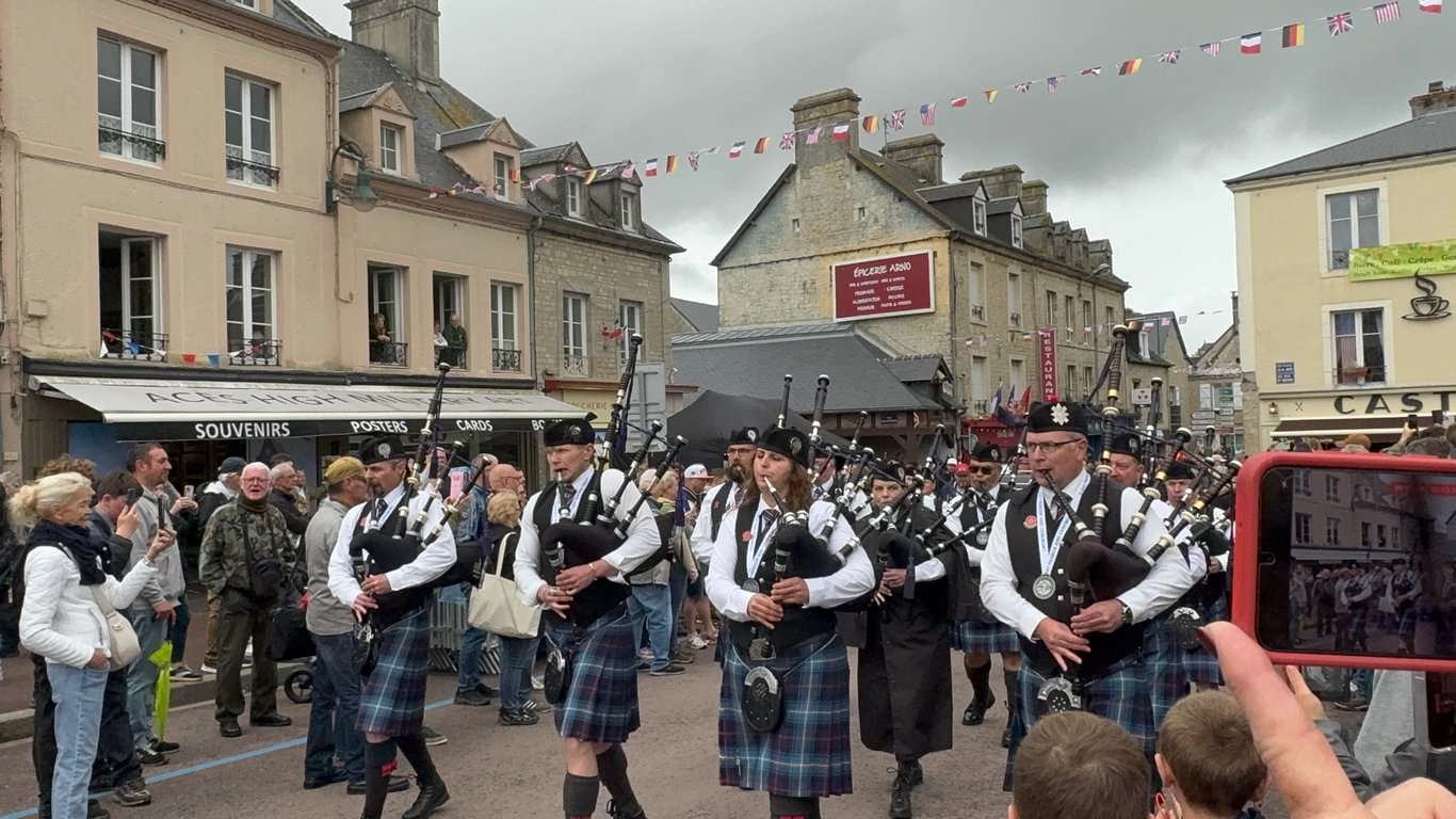 Utah Pipe Band marching through the streets of Sainte-Mere-Eglise during D-Day anniversary celebrations