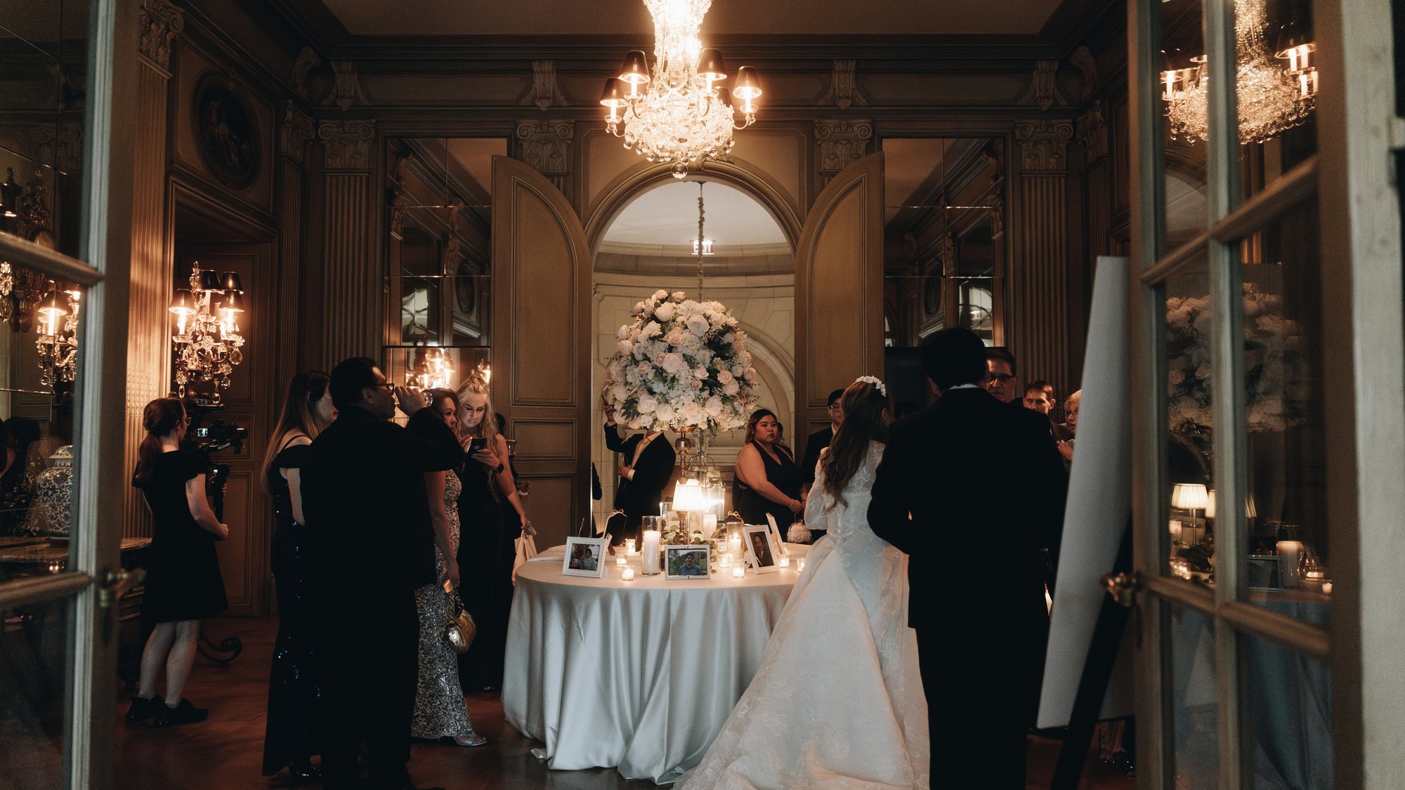 The couple at their table, seen from the next room through the doorway
