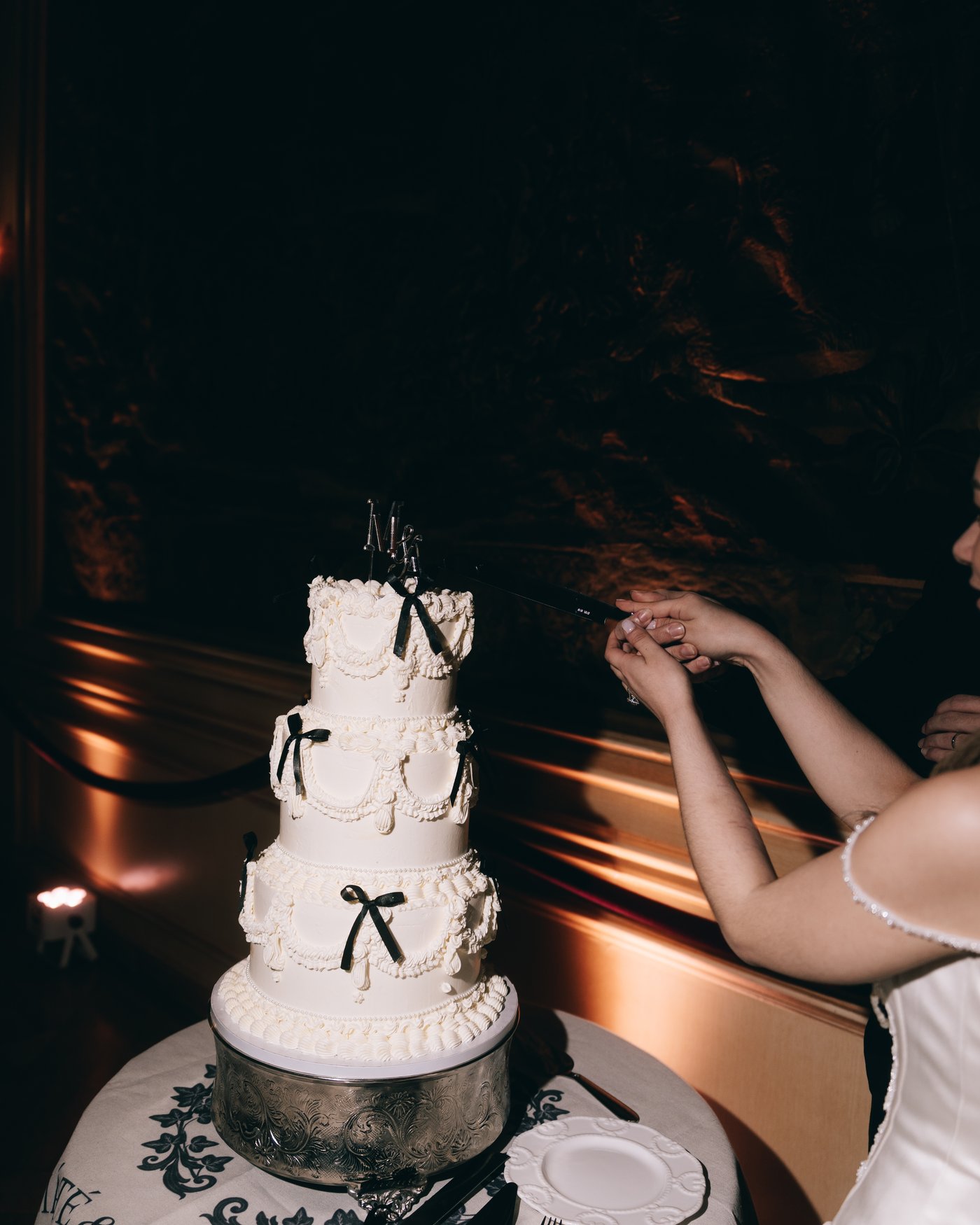 Hands cutting the first slice from the cake