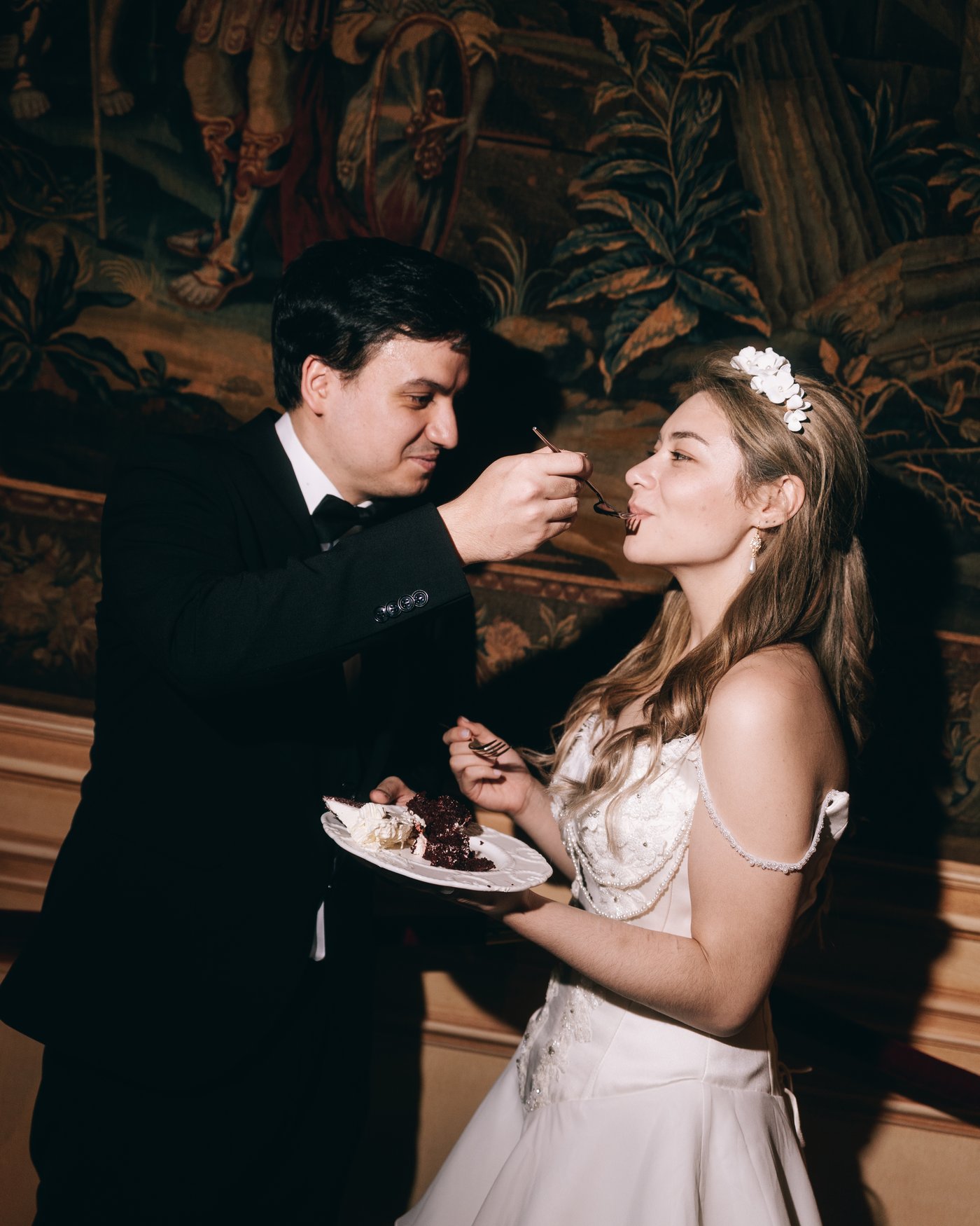 The groom feeding the bride a forkful of cake