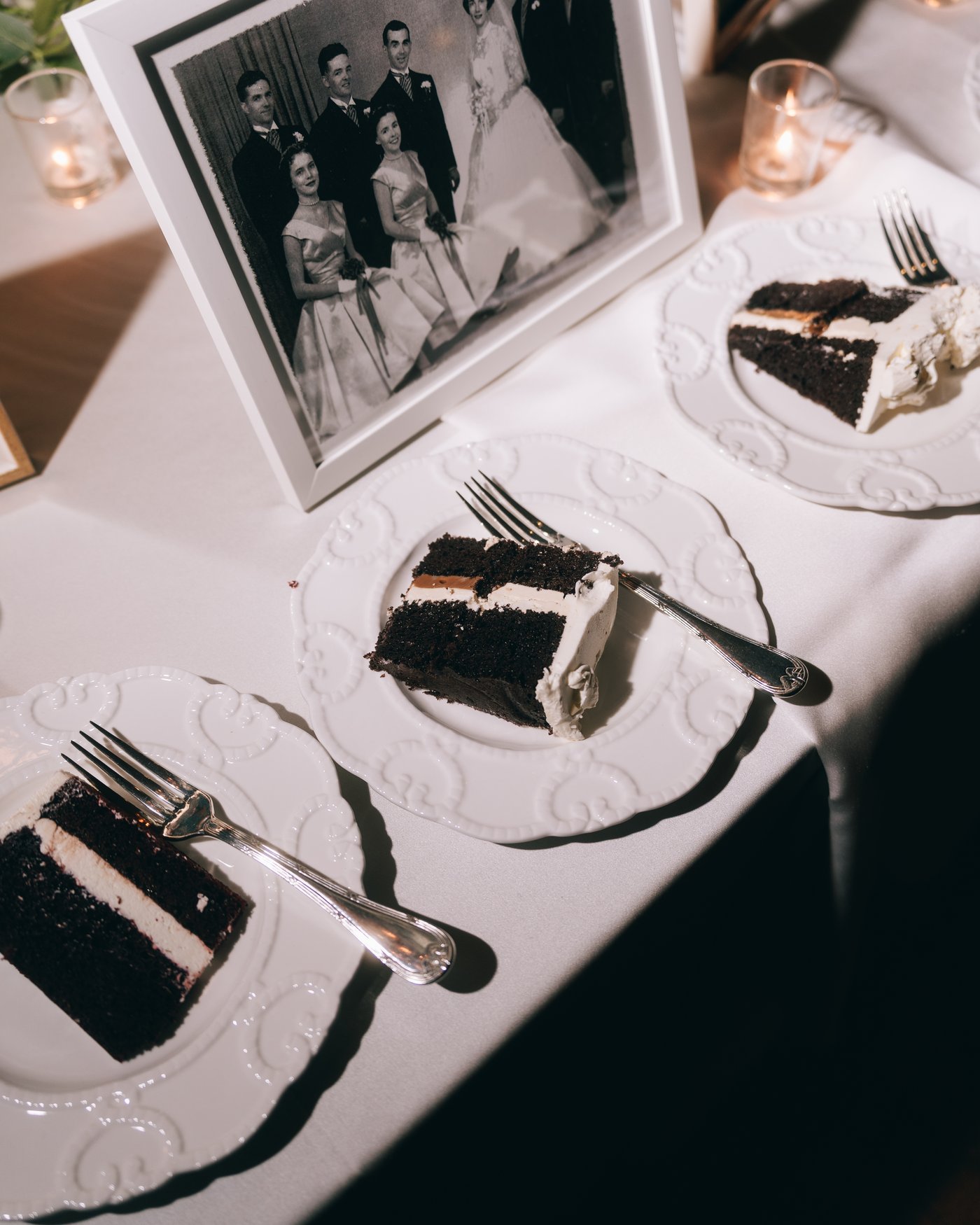 Slices of cake on plates beside an old black and white family photograph