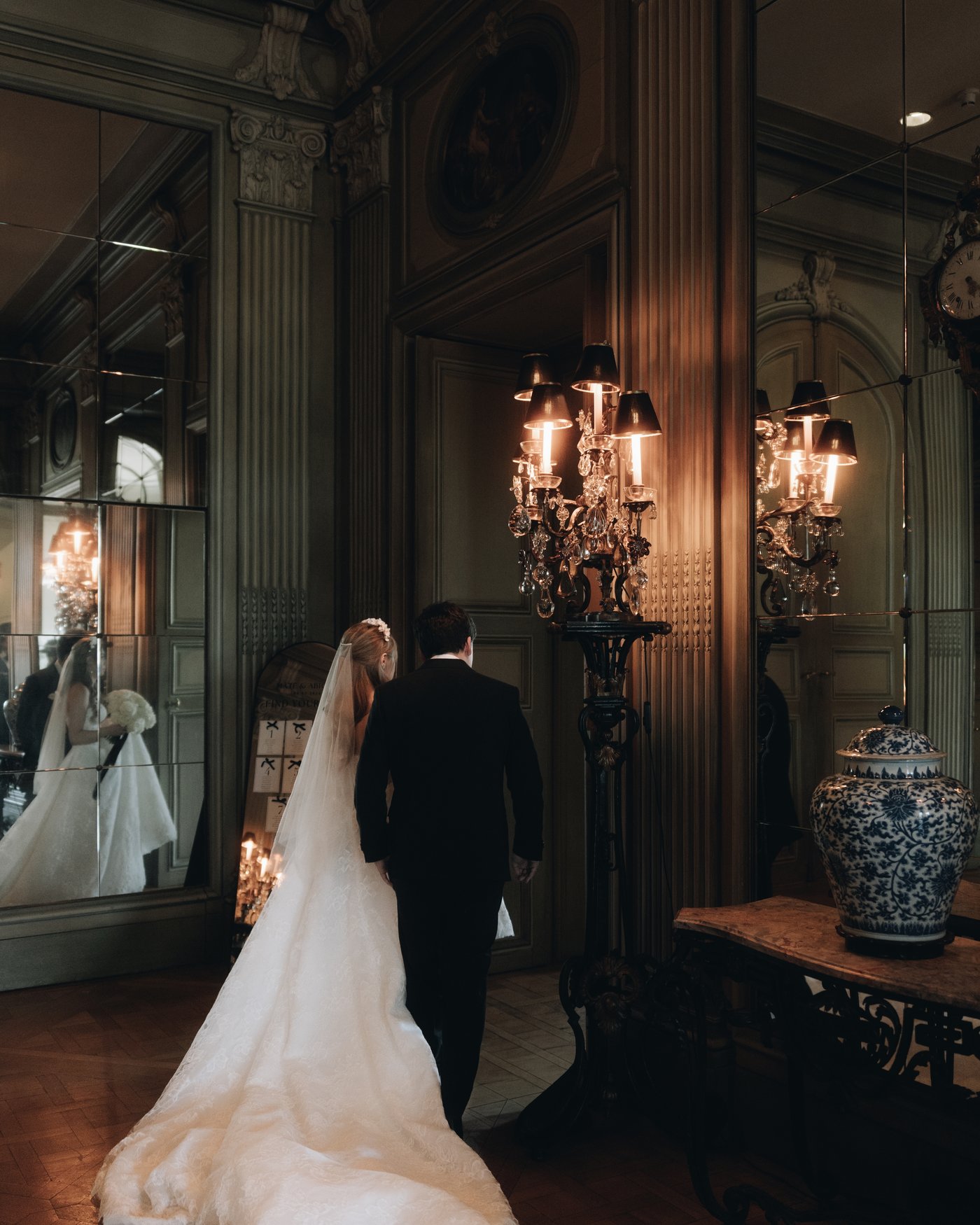 The bride walking through the panelled hall in a long train