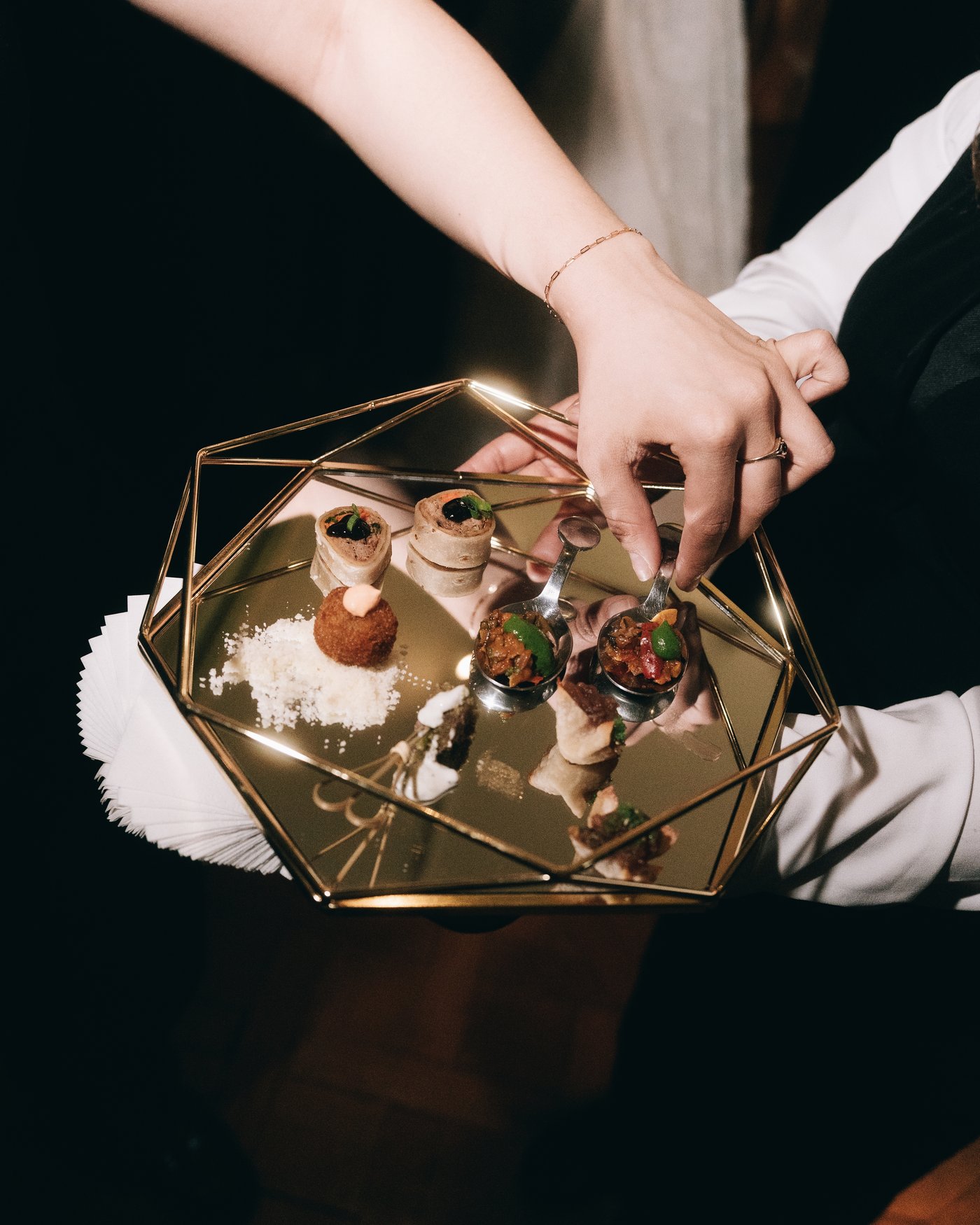 Hands holding a small glass and brass box of rings