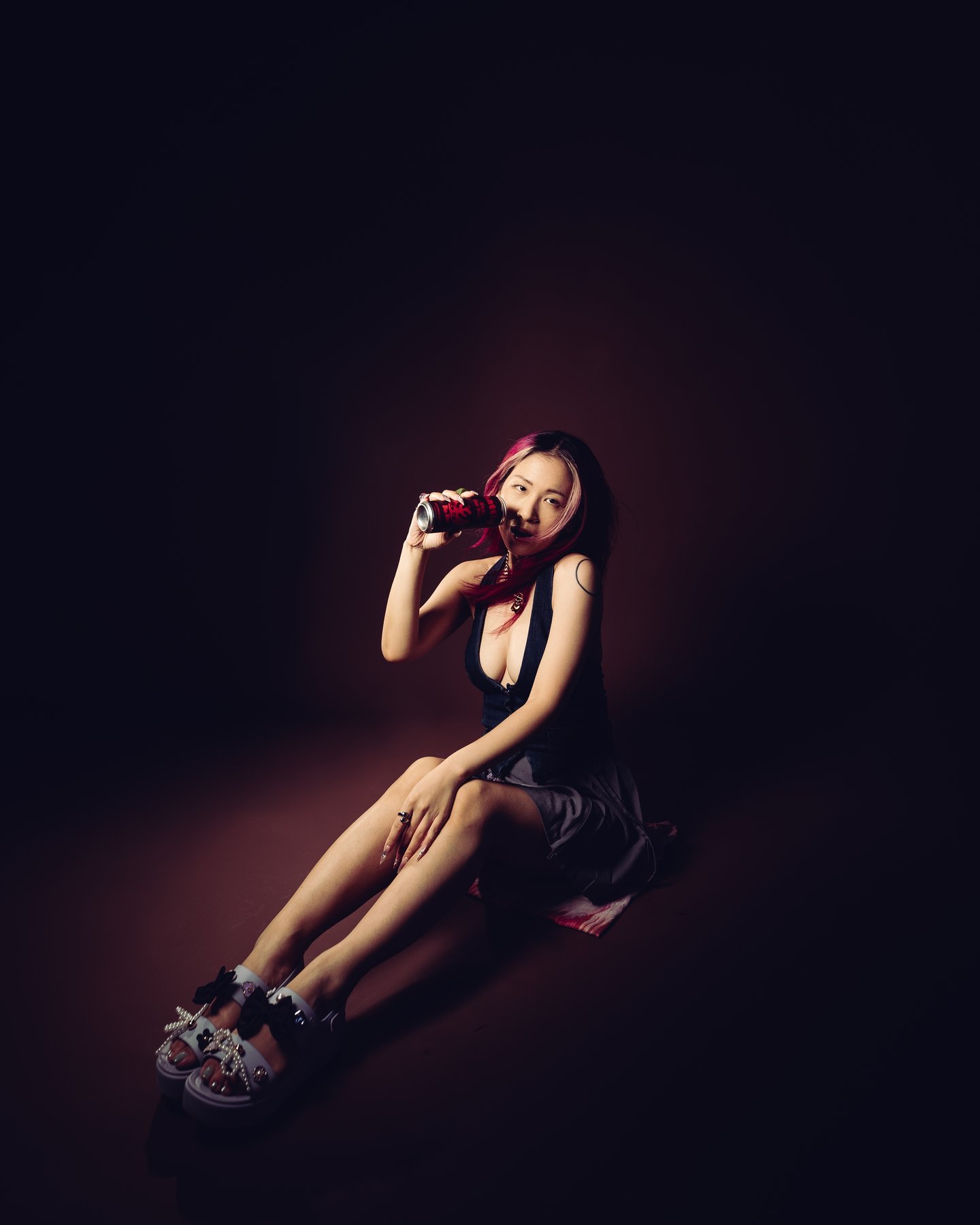 Crouched on the studio floor in platform sneakers, hands in her hair