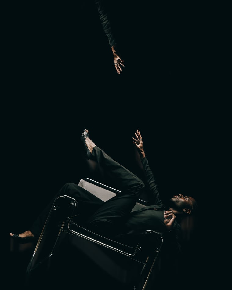 The same figure falling backwards over the chair, one arm flung up, another hand reaching down out of the dark above him