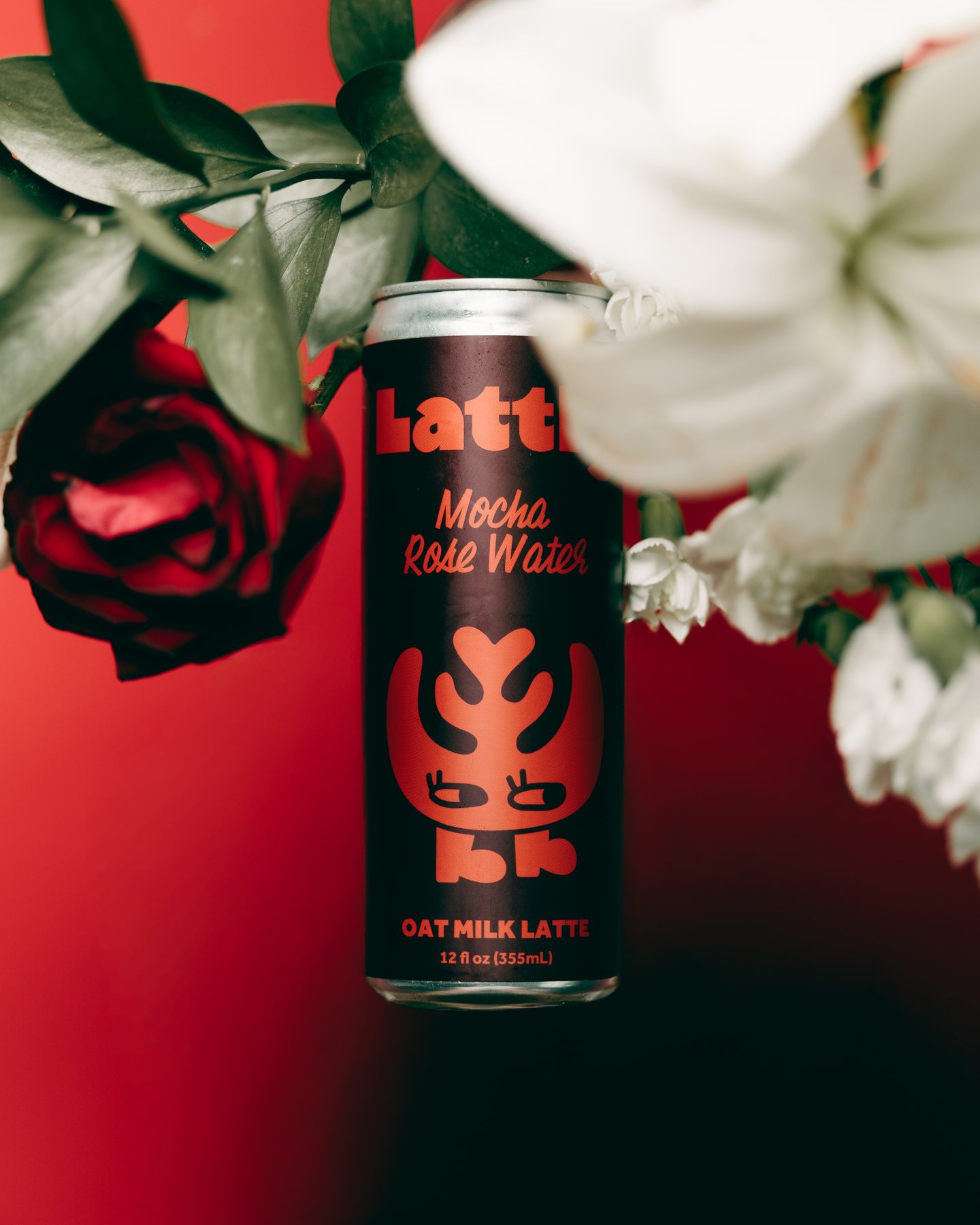 A Lattly Mocha Rose Water can among red roses and white lilies