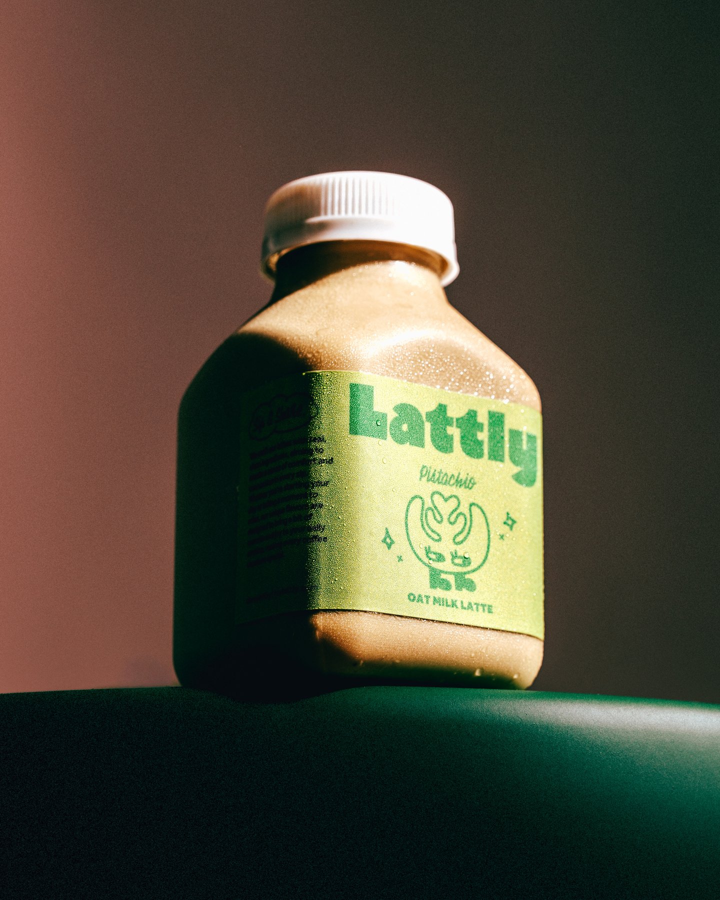 One Lattly bottle standing on a dark green ground