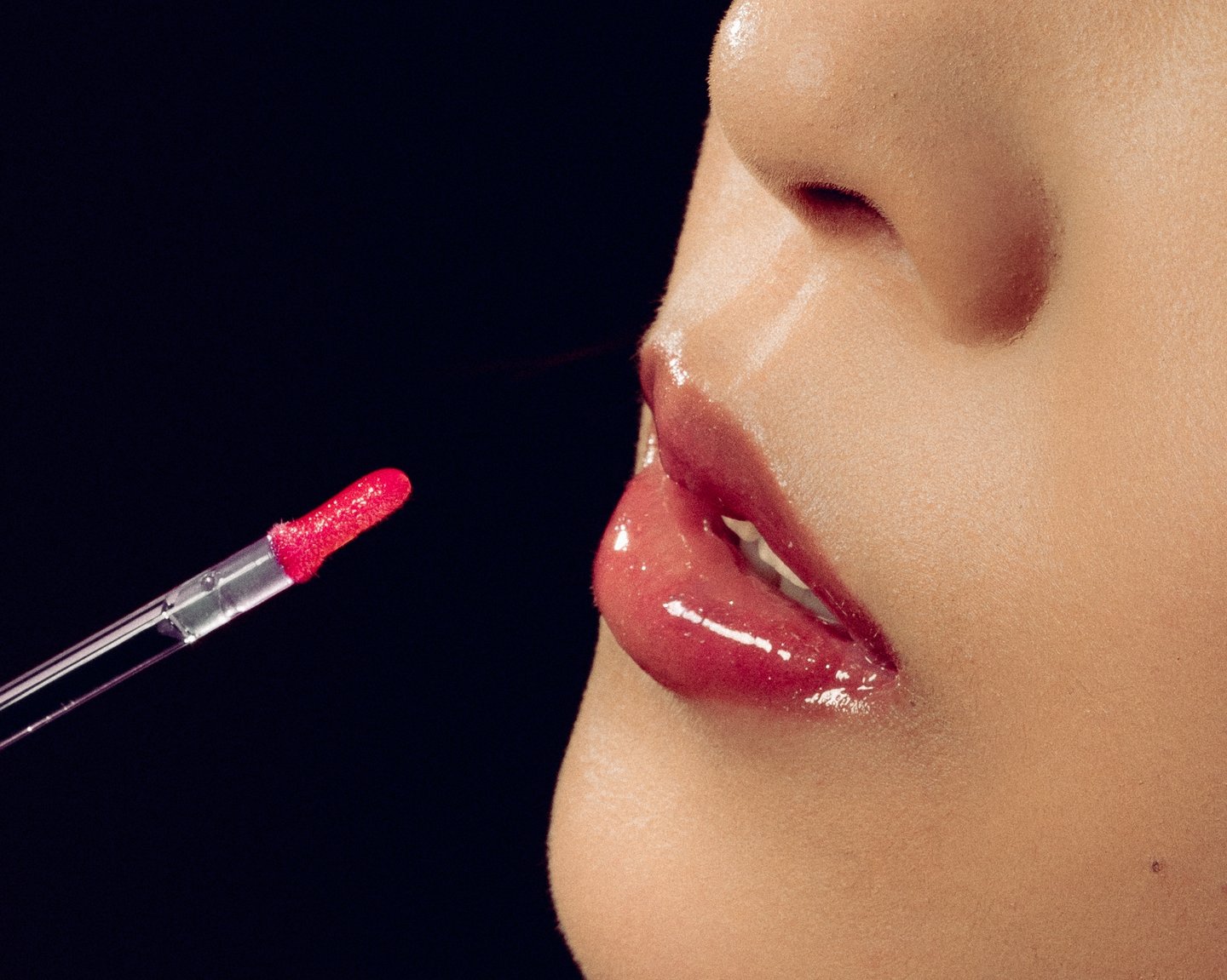 An extreme close crop of lips and the gloss wand