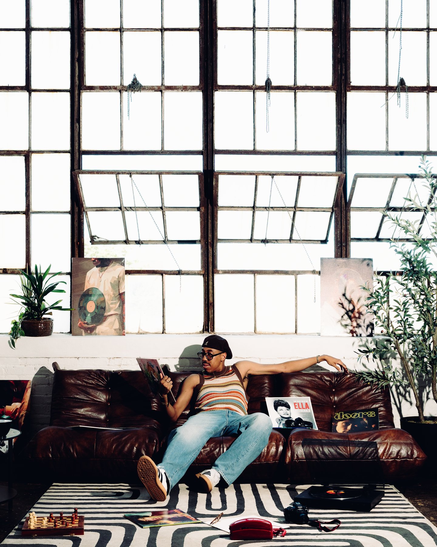 Kyle lying across the leather sofa under the loft windows, a magazine open