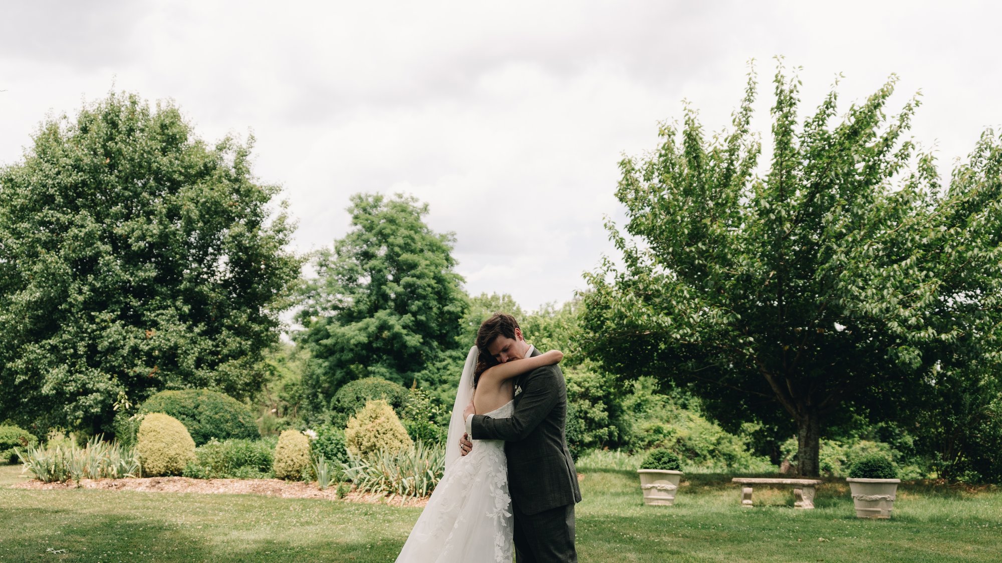 The bride and groom holding each other on the lawn after the first look