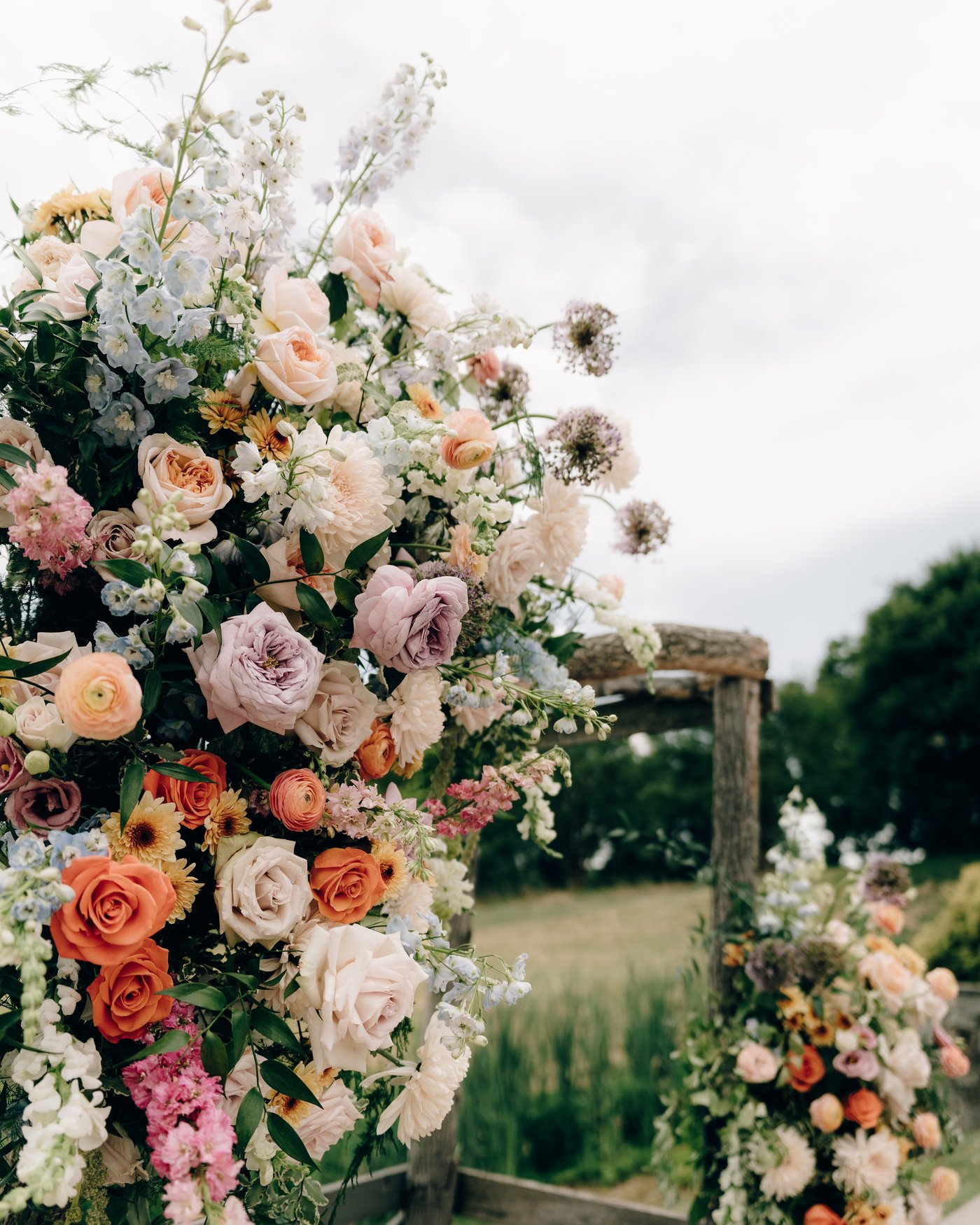 A tall floral arrangement of peach, coral and cream blooms