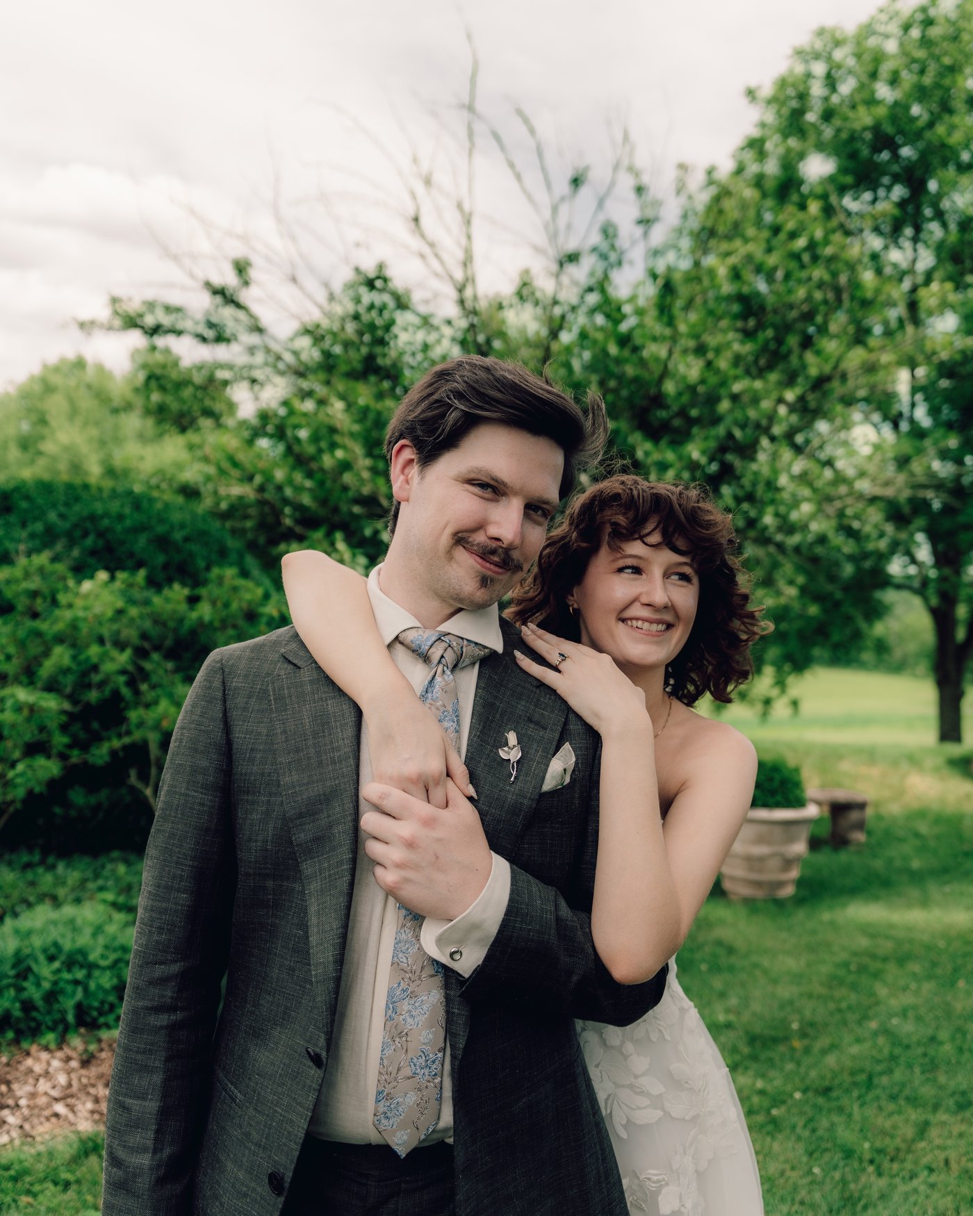 The bride and groom pressed together laughing, the valley behind them